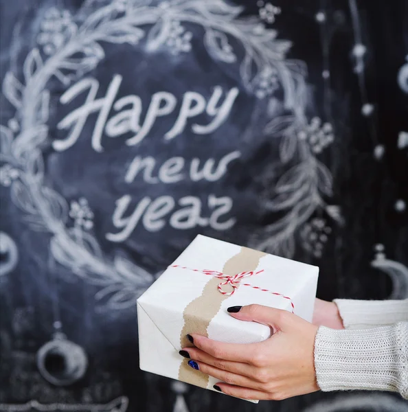 Frauenhände halten verpackten Geschenkkarton — Stockfoto