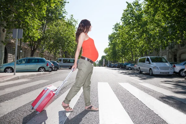 Donna incinta con valigia in passerella — Foto Stock