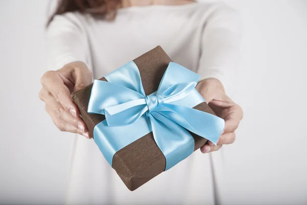 Regalo marrón y azul en manos de mujer —  Fotos de Stock