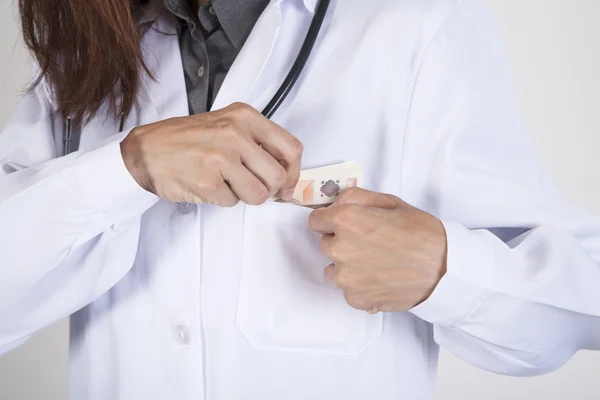 Doctor tucking a wad of Euros in her pocket — Stock Photo, Image