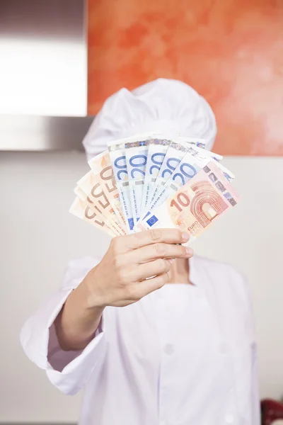 Wad de notas de euro na mão do chef — Fotografia de Stock