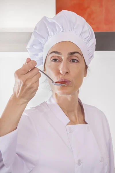 Vrouw chef-kok proeven saus — Stockfoto
