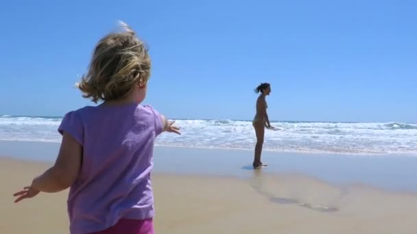 Bebé en la playa llamando lejos mujer madre en la orilla — Vídeo de stock