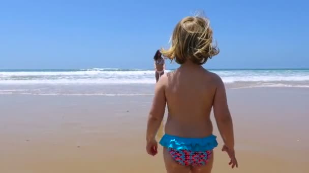 Bébé sautant et courant vers la mère à la plage — Video