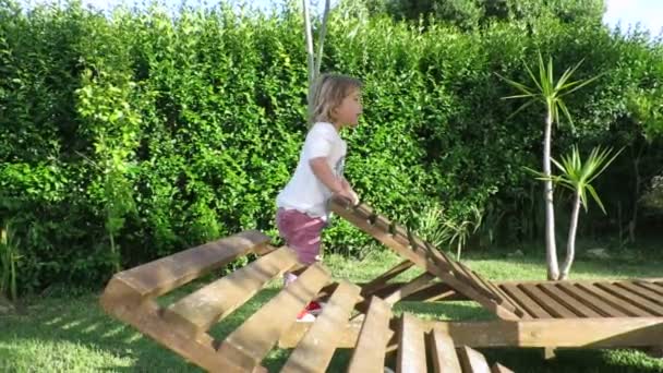 Bambino due anni saltando su amaca di legno rallentatore — Video Stock