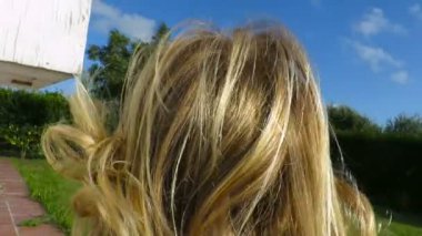 bahçede çalışan ve çim yavaş hareket üzerinde düşen geri sarışın bebek