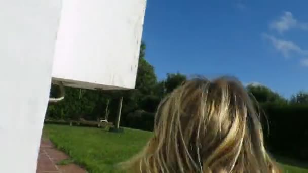 Назад блондинка біжить в саду і падає на траву — стокове відео