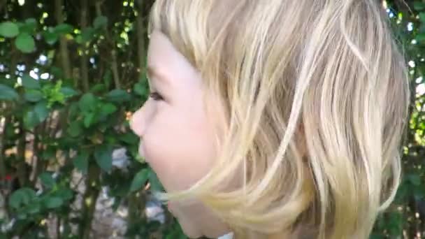 Закрыть счастливое милое лицо ребенка, веселясь и ударяя камеру замедленного действия — стоковое видео