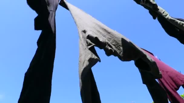 Линия одежды, движущаяся над синим небом — стоковое видео