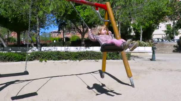 Bébé balançant dans le parc urbain aire de jeux — Video