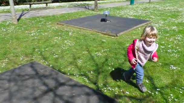 Счастливый ребенок бежит на детской площадке зеленая трава замедленного движения — стоковое видео