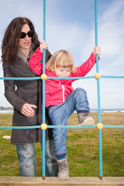 Winter baby climbing rope ladder — Stock Photo, Image