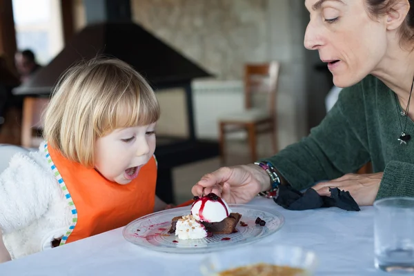 Überraschtes Gesicht Kind isst Kuchen mit Mutter — Stockfoto