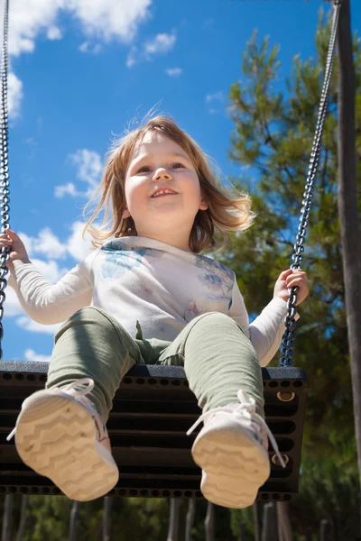 Low angle view of child swinging at park — Stock Photo, Image