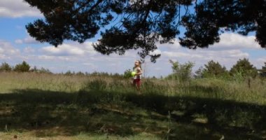 4k video. Dört yaşında sarışın bir kız elinde topla Guadarrama 'daki kırsal alanda annesinin yanında Madrid, İspanya ve Avrupa' ya yakın bir yerde yürüyor.