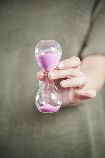 Reloj de arena rosa en la mano — Foto de Stock