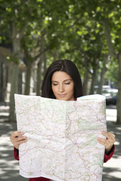 Smiling woman watching a map — Stock Photo, Image