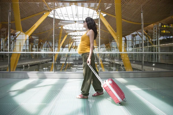 Schwangere zieht Koffer in Flughafen — Stockfoto