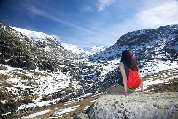 Mulher sentada em um vale de neve — Fotografia de Stock