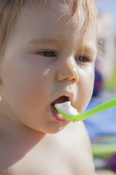 Bebé comiendo cuchara de plástico verde — Foto de Stock