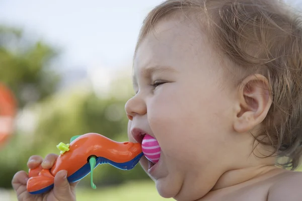 Barnet äta plast leksak — Stockfoto