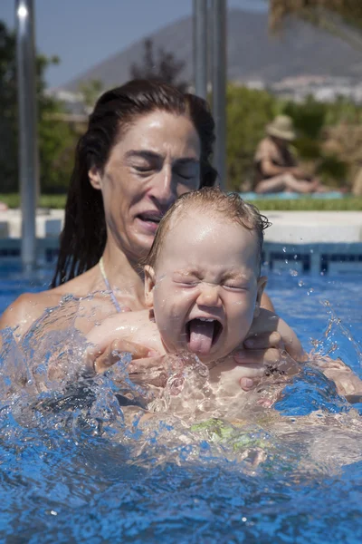 Bebê espirrando na piscina com a mãe — Fotografia de Stock