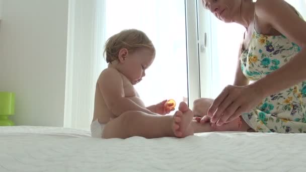 Mère appliquant bébé crème — Video