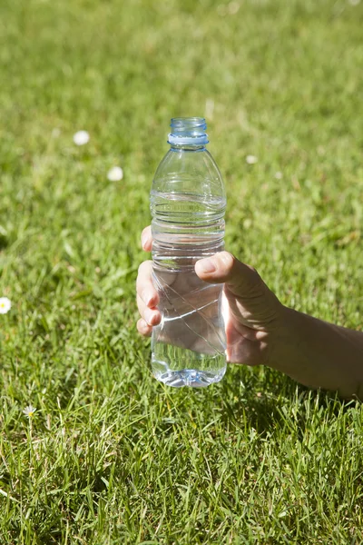 Open water plastic bottle in hand — Stock Photo, Image