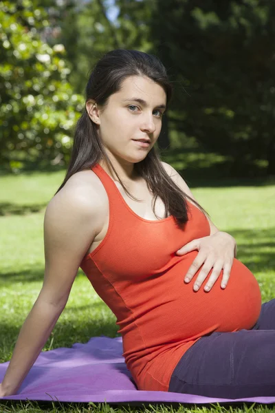 Pregnant touching baby looking at camera — Stock Photo, Image