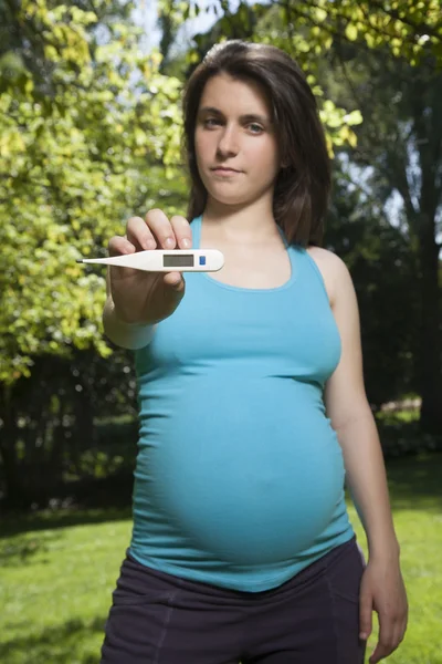 Pregnant showing thermometer — Stock Photo, Image