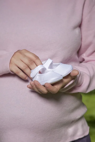 Botines blancos en las manos de mamá — Foto de Stock