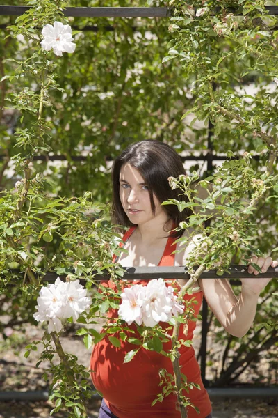 Joven embarazada entre flores — Foto de Stock