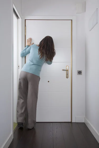 Back woman looking at peephole — Stock Photo, Image