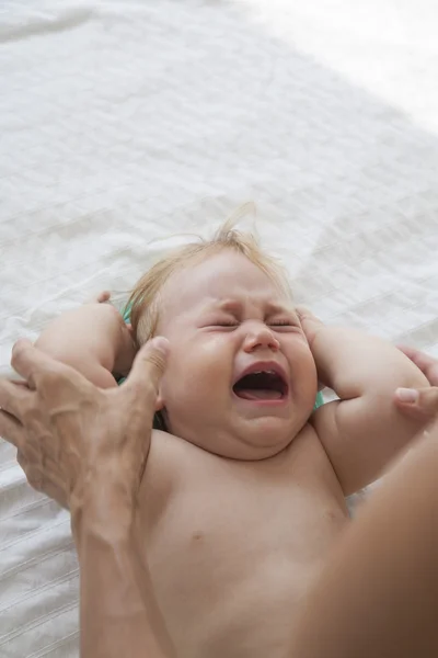 Bebê chorando na cama branca — Fotografia de Stock