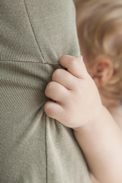 Closeup baby hand holding mom dress — Stock Photo, Image