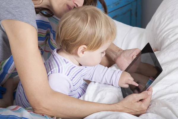 Baby touching tablet on bed — Stock Photo, Image