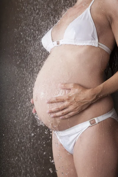 Karın hamile beyaz bikini elleri — Stok fotoğraf
