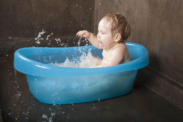 Blonda baby tvätta i blå lite bad inomhus — Stockfoto