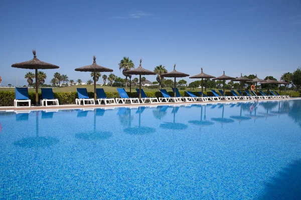 Pool side with hammocks and umbrellas — Stock Photo, Image