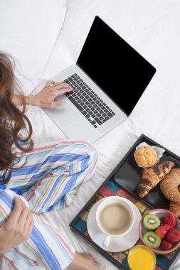 laptop ve yatakta kahvaltı