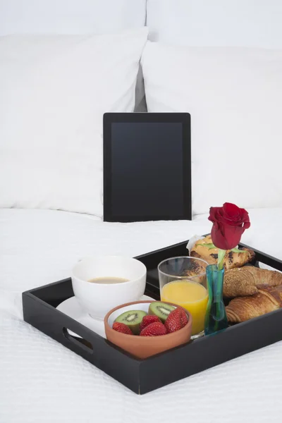 Сніданок і планшет на ліжку — стокове фото