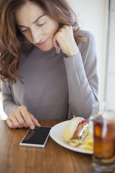 Frau mit Telefon und Sandwich — Stockfoto