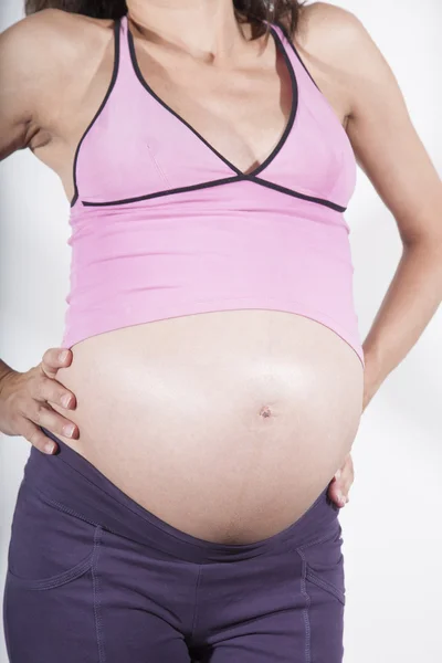 Detail of pregnant tummy pink shirt — Stockfoto