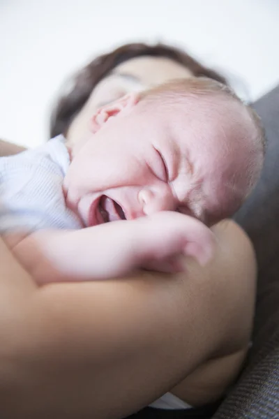 Newborn crying on mom shoulder — Stockfoto