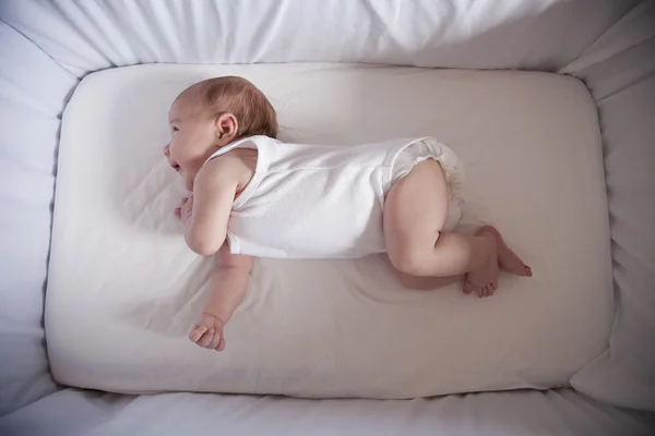 Newborn laughing in cradle — Stock fotografie