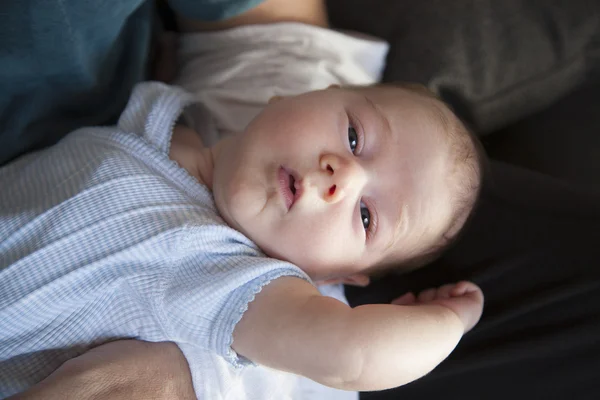 Newborn on man arms looking — Stock Photo, Image