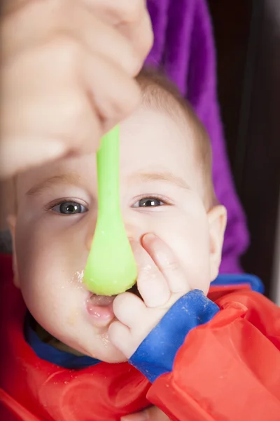 Eating green plastic spoon — Stock Photo, Image