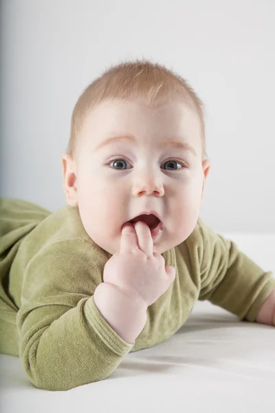 Visage regardant bébé vert onesie — Photo
