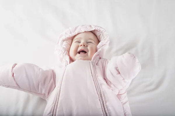 Laughing baby gezicht in roze snowsuit — Stockfoto