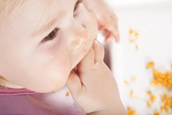 Над головой ребенок ест руками — стоковое фото